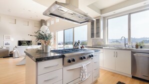 A modern kitchen with a large island, stainless steel appliances, and a view of the outdoors. - Seascape by Avantstay Spacious Contemporary Oasis in Del Mar (Del Mar)