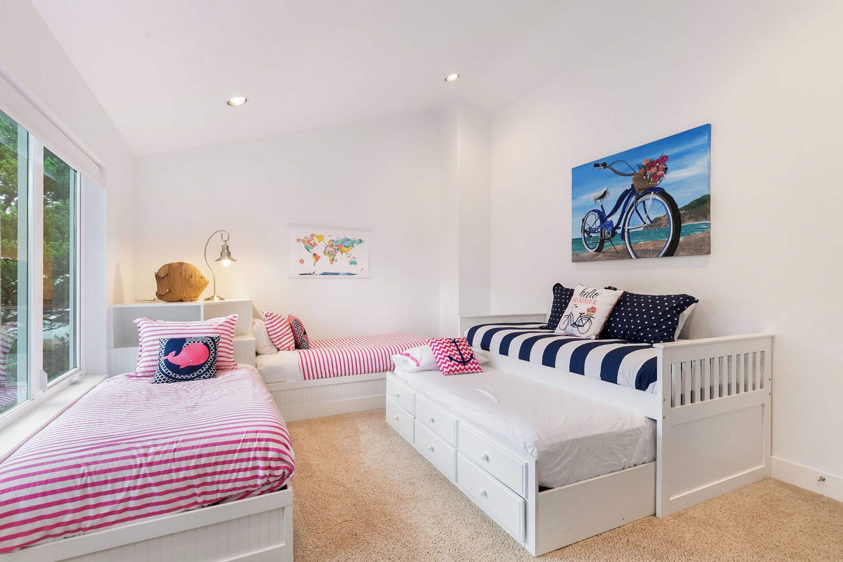 A bedroom with two beds, a map on the wall, and a bicycle painting.