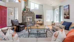 A living room with a fireplace, leather chairs, a glass coffee table, and a sofa. - Villa Manzanita by Avantstay Hot Tub, 1 Block to Beach/town, Chef's Kitchen (Manzanita)