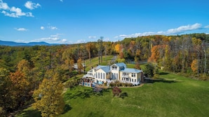 A large, two-story house with a spacious front yard and a driveway leading to the entrance.