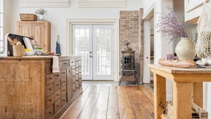 A kitchen with wooden cabinets, a brick wall, and a large window.