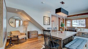 A dining area with a large wooden table, chairs, a bench, and a chandelier. - Hillside Overlook by Avantstay Quiet Mountain Getaway w/ Incredible Views! (Park City)