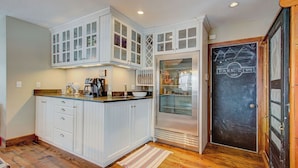 A kitchen with white cabinetry, a coffee machine, and a refrigerator. - Hillside Overlook by Avantstay Quiet Mountain Getaway w/ Incredible Views! (Park City)