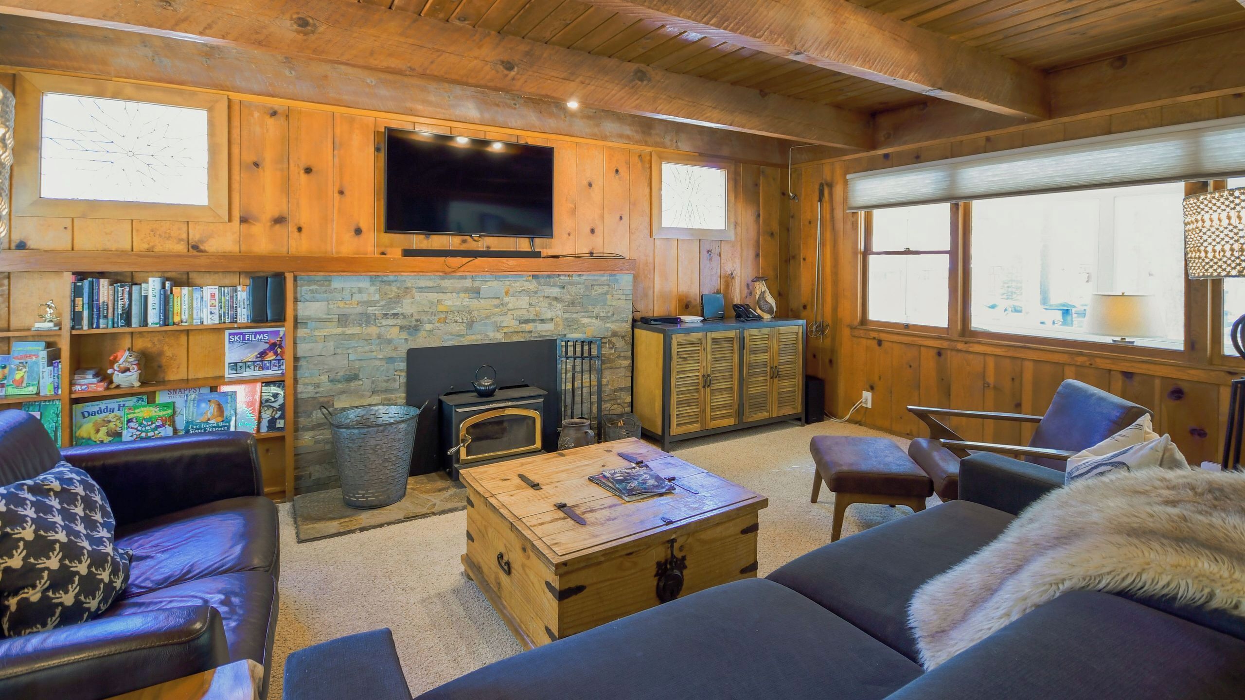 A cozy living room with a fireplace, a television, and a bookshelf.