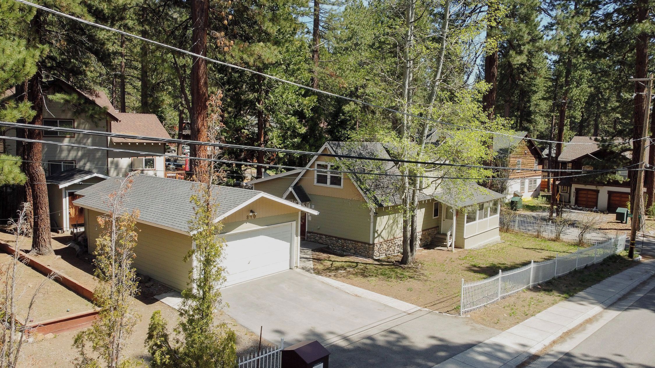 A residential area with houses, a street, and power lines.