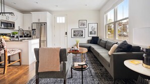 A modern kitchen with white cabinets, stainless steel appliances, and a dining area with a round table and chairs. - Hart Suite Buyout 3 by Avantstay Two Town House Buyout w/ Modern Amenities in Nashville! (Nashville)