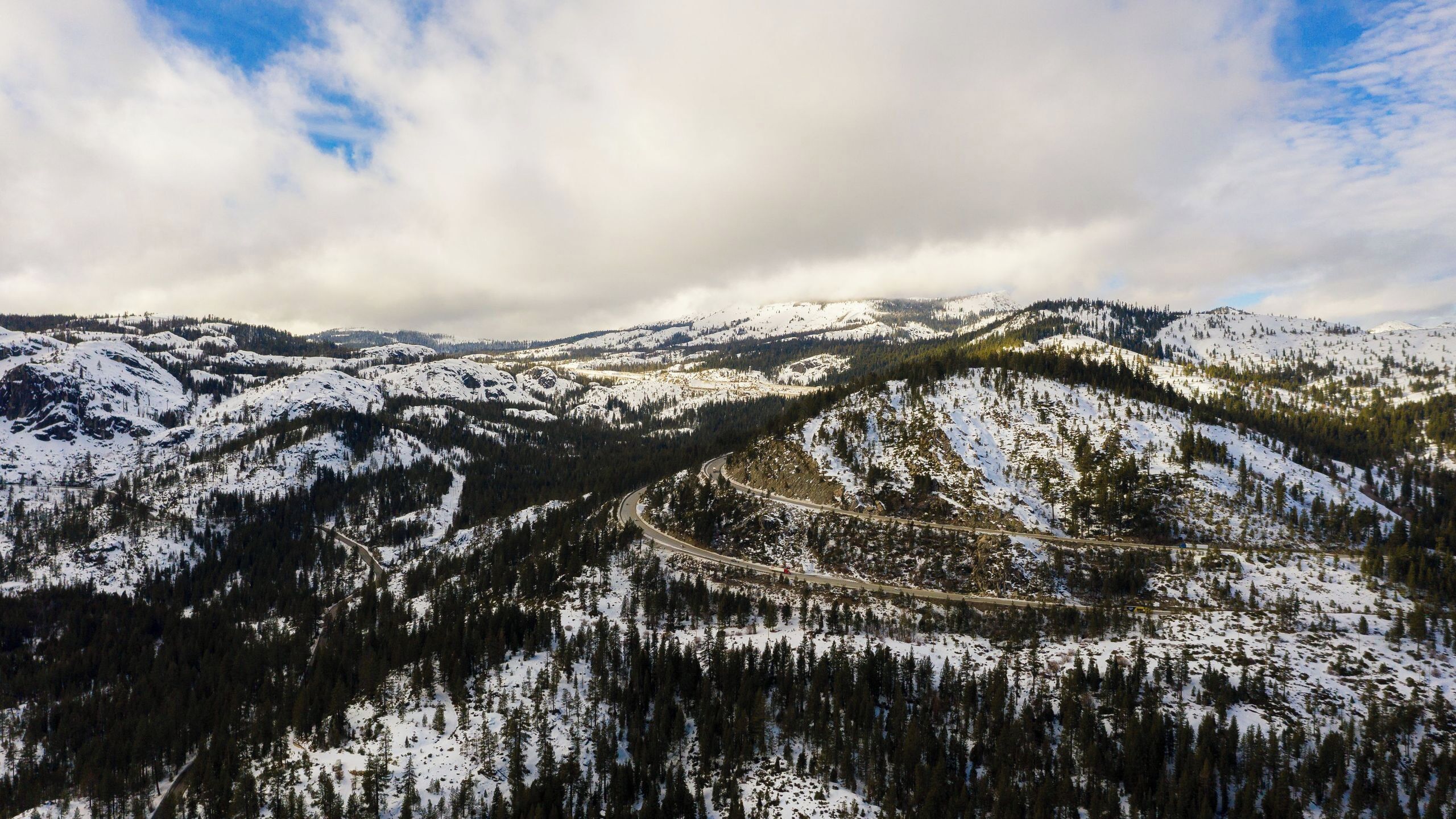 A snow-covered mountainous landscape with a winding road.