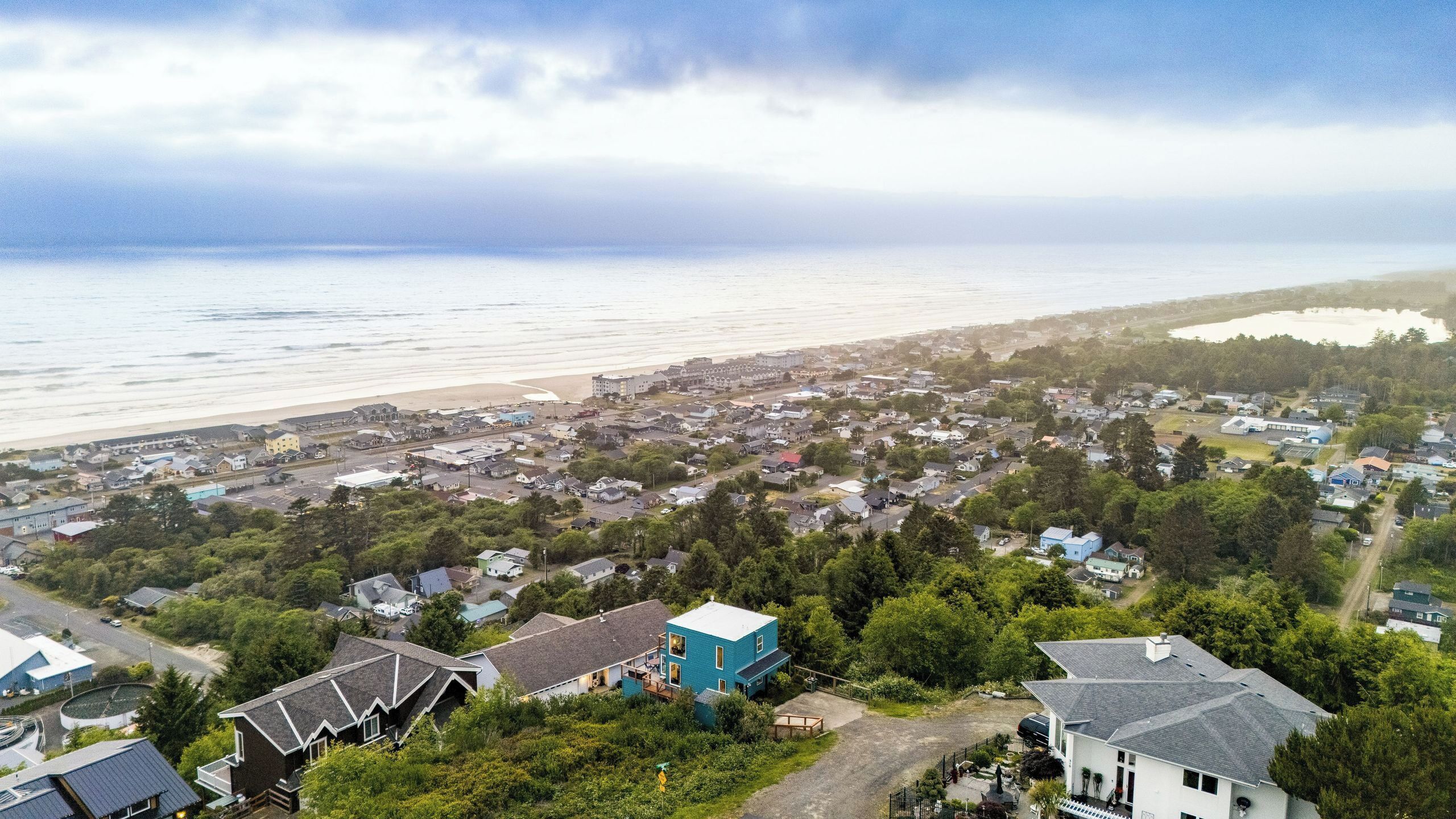 Une ville côtière avec une plage, des maisons et une vaste étendue d’eau.