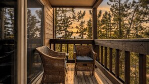 A wooden deck with wicker chairs and a table, overlooking a forested area. - Pinegrove by Avantstay Beautiful Villas Condo Just Outside Tahoe City! (Tahoe City)