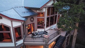 A multi-level house with a balcony, outdoor seating, and a staircase.
