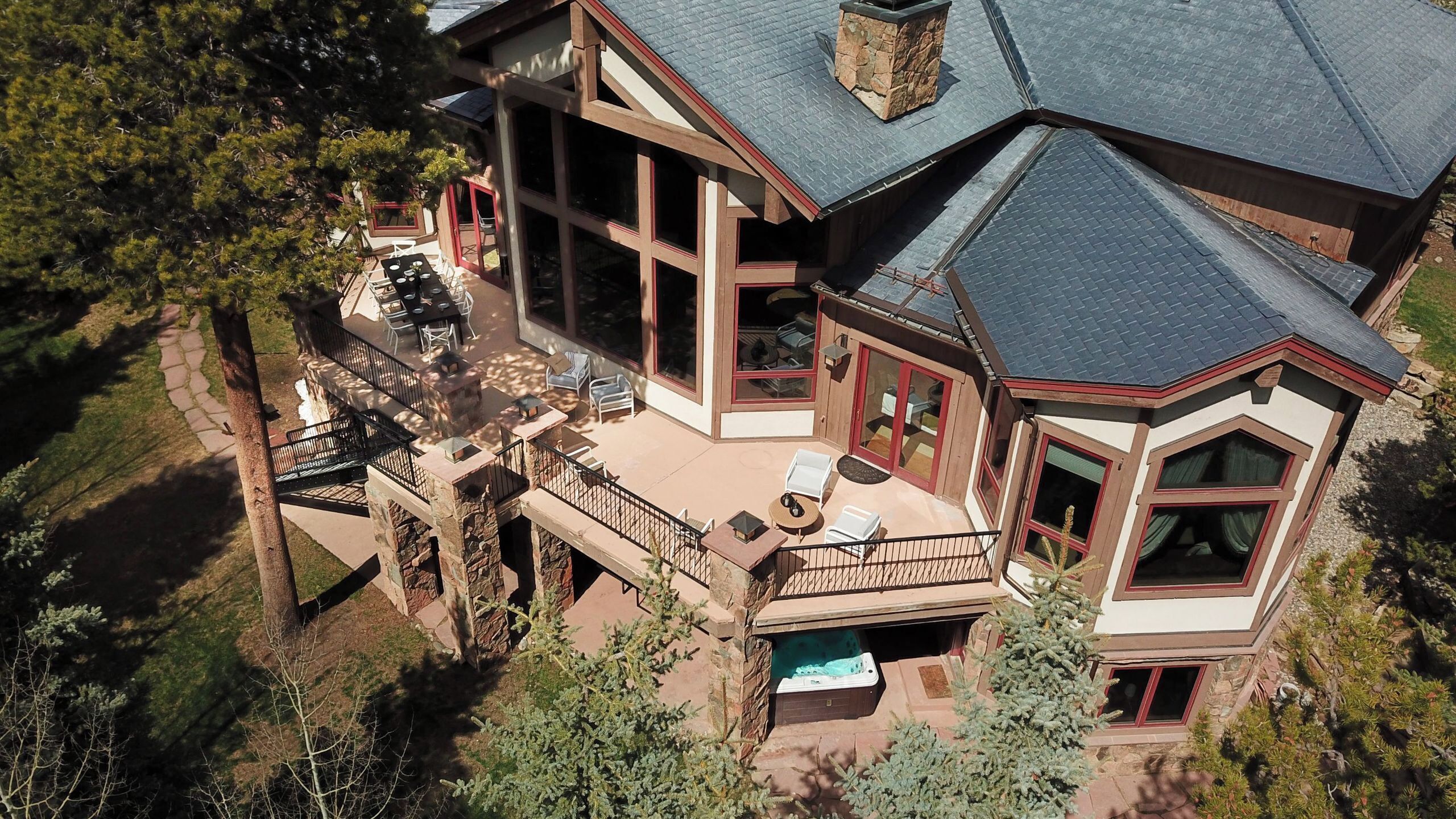 A large house with a balcony, a hot tub, and a patio area.