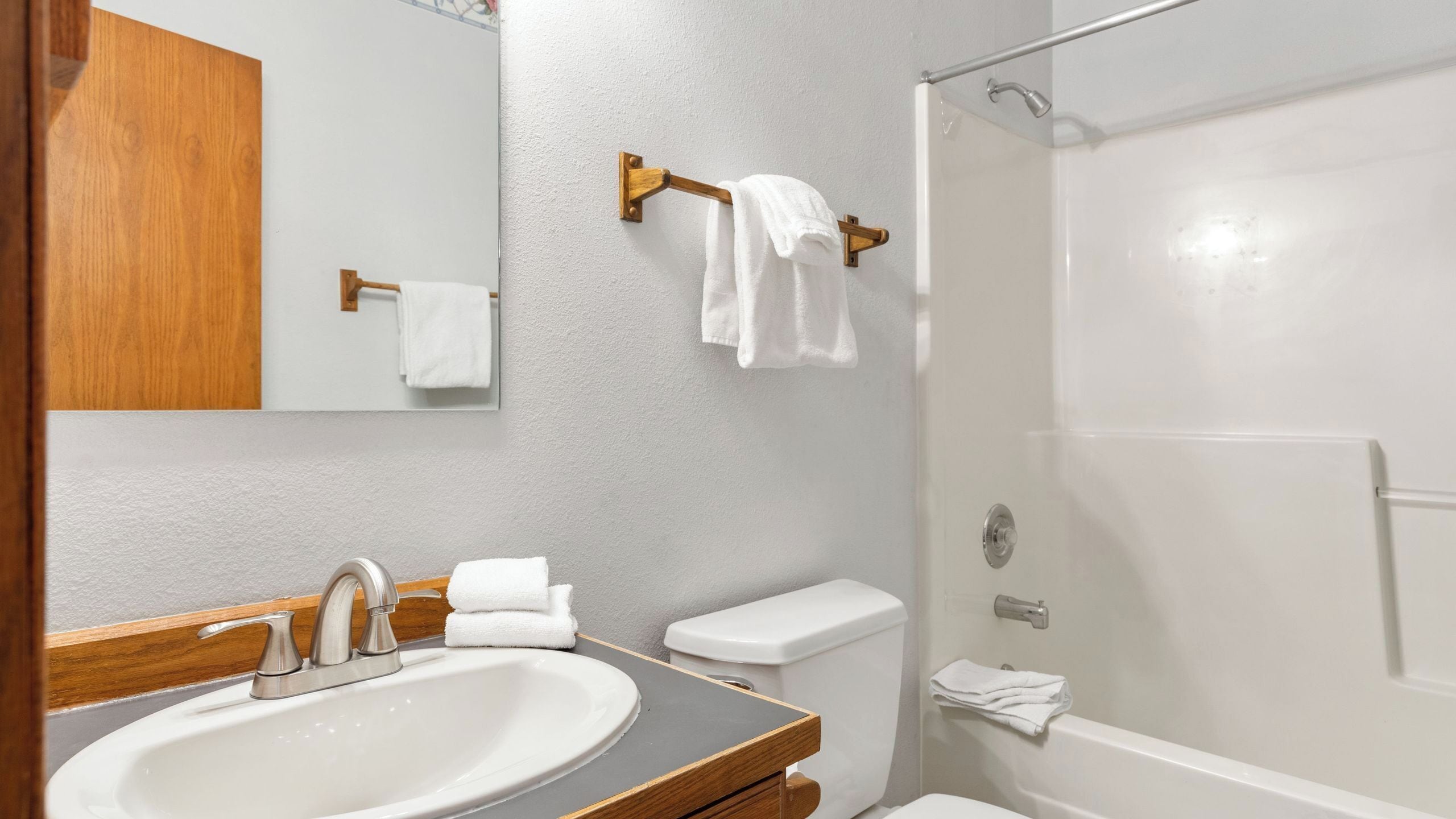 Une salle de bain équipée d’un lavabo, d’un miroir, de toilettes et d’une douche.