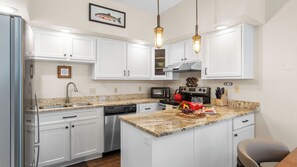 A modern kitchen with white cabinets, granite countertops, stainless steel appliances, and pendant lighting. - Ghostriders 2 by Avantstay Tidy Unit Close to the Slopes and Shops! (Telluride)
