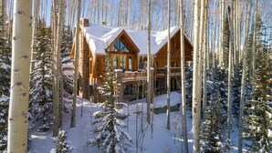 A log cabin with a balcony, surrounded by snow-covered trees. - Snowdrift Cabin by Avantstay Breathtaking Home w/ Prime Ski Access (Telluride)