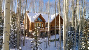 A log cabin with a balcony, surrounded by snow-covered trees. - Snowdrift Cabin by Avantstay Breathtaking Home w/ Prime Ski Access (Telluride)