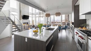 A modern kitchen with a central island, stainless steel appliances, and a large window providing natural light. - Silverado by Avantstay Snowboarder's & Skiers Paradise w/ Hot Tub, Views & Easy Slope Access! (Park City)