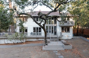 A two-story house with a balcony, a front porch, and a small front yard.