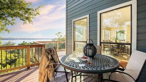 A deck with a table, chairs, and a view of the water. - Dawson by Avantstay Serene Austin Home set Amongst Nature w/ Pool & Close to Lake Travis (Austin)