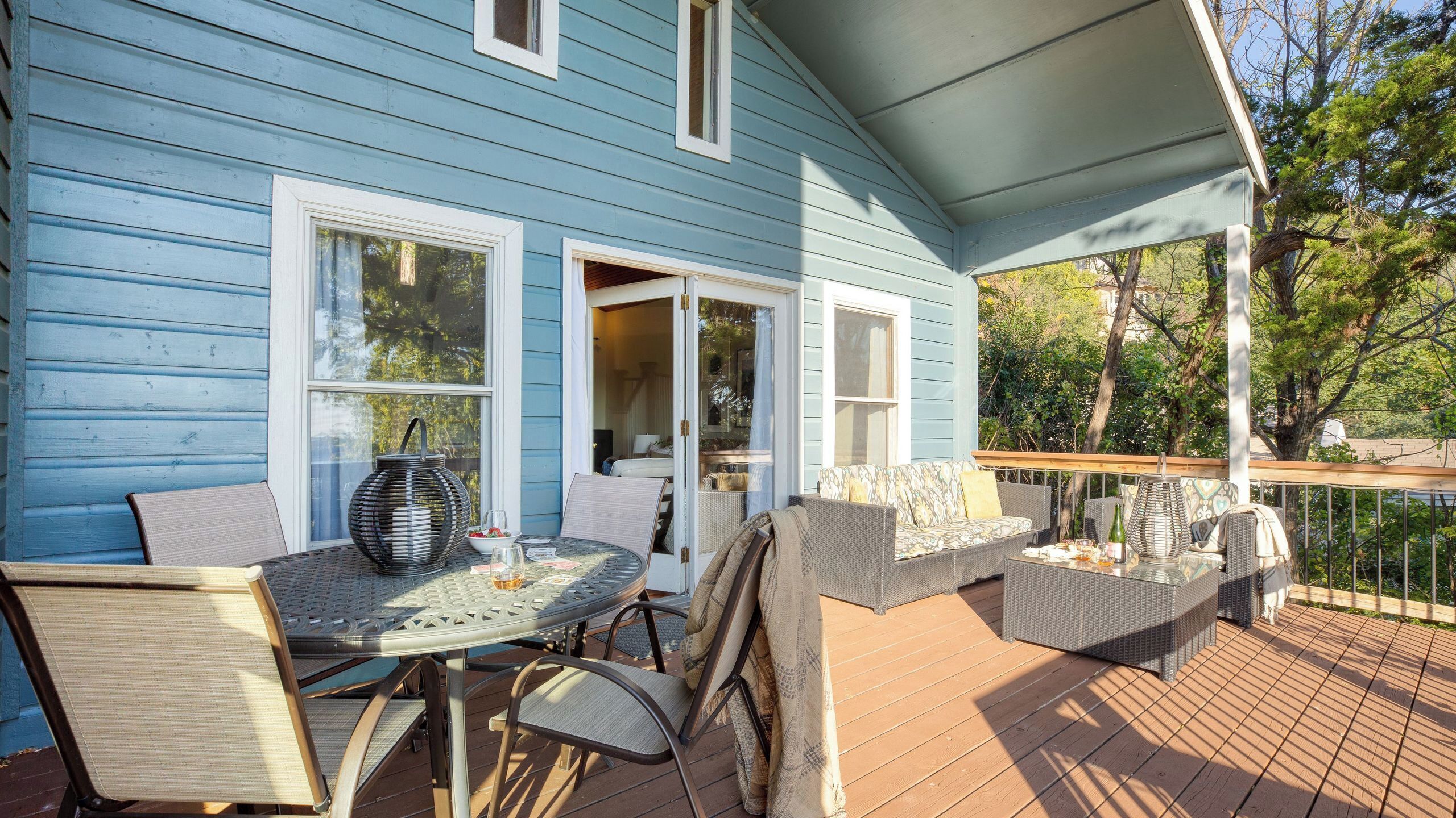 Una terraza techada con mobiliario exterior, una mesa y una silla.