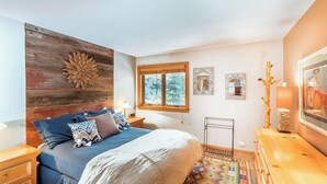 A bedroom with a bed, wooden wall decor, a window, and a bedside table with a lamp. - Cimarron Lodge 20 by Avantstay Ski In/ Ski Out Condo in Ideally Located Complex w/ Hot Tubs! (Telluride)