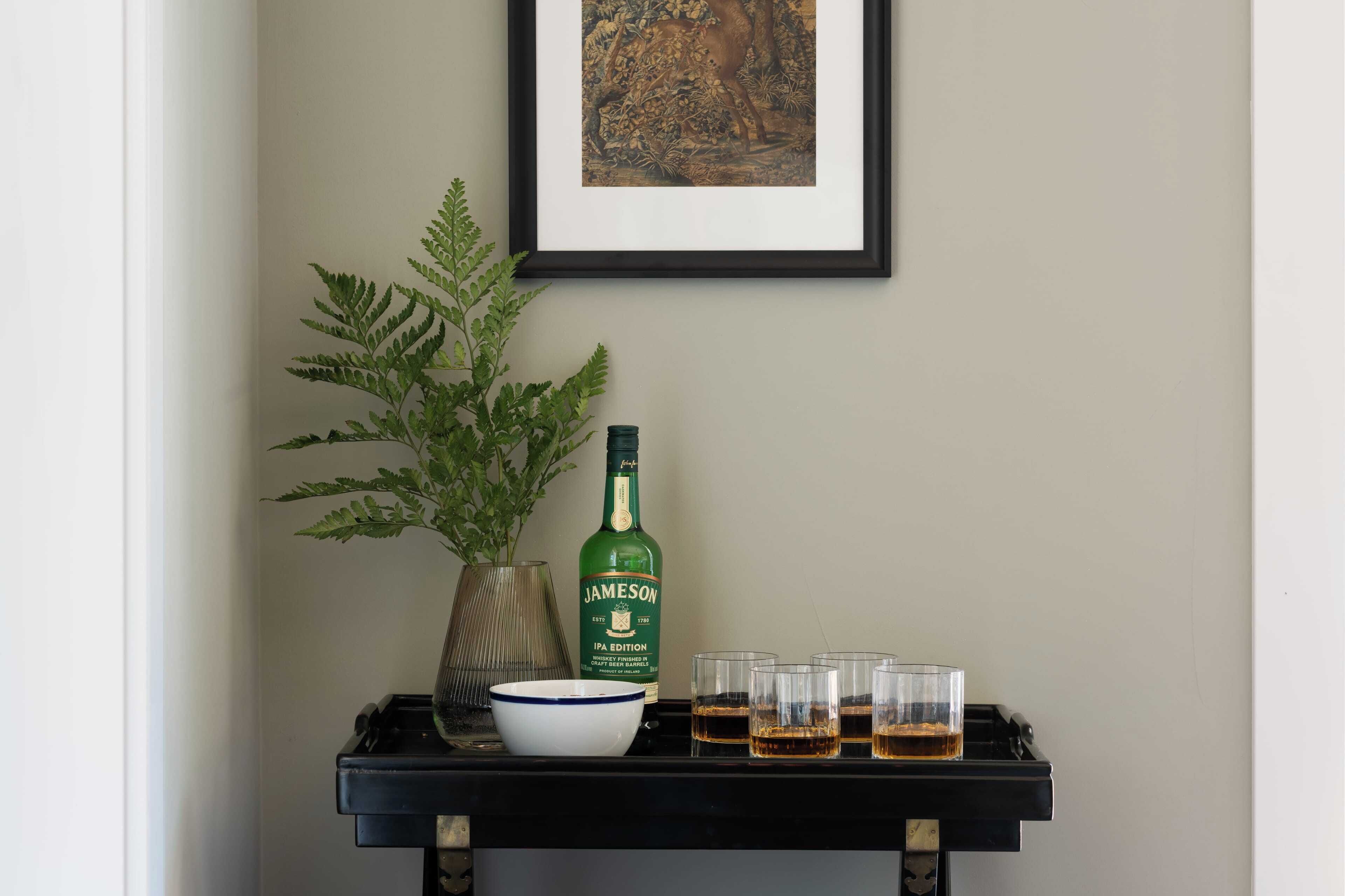 Una zona de bar con una botella de Jameson IPA, un bol y vasos de whiskey.