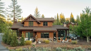 A modern two-story house with a stone foundation, large windows, and a patio with outdoor furniture. - Quartz by Avantstay Stunning Home In Truckee w/ Views (Truckee)