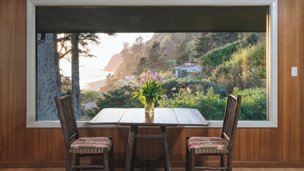 Una habitación con paneles de madera y un amplio ventanal con vistas a un paisaje montañoso.