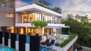 A modern two-story house with a swimming pool, outdoor seating, and a glass balustrade overlooking a lush garden. - 5 star BEACHVIEW PH W/ ROOFTOP TERRACE &JACUZZI (Las Terrenas)