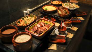 Ein Buffet mit verschiedenen Speisen, darunter Reis, Fleisch und Gemüse.