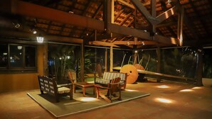 An outdoor seating area with wooden furniture and a large drum. - Hotel Fazenda Bela Vista (Dourado)