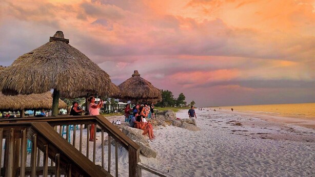 A beach with thatched-roof huts and a wooden walkway. - Casa Das Palmas | Beautiful 3 Bed/2 Bath Home with screened Heated Pool | Minutes to Anna Maria Island Beaches | Sleeps 8 (Bradenton)