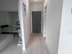 Relax in a cozy space with a neatly arranged bed, compact seating area, and exercise bike.