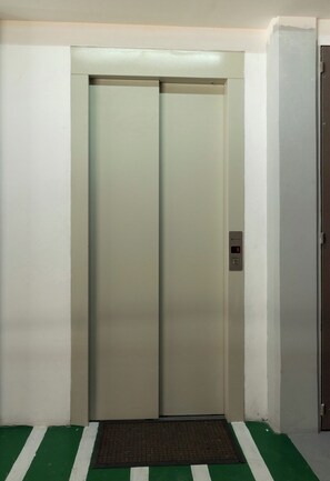 Een gesloten lift met een digitaal bedieningspaneel aan de rechterkant.