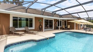 Een zwembad met ligbedden en parasols, omgeven door een overdekt terras.