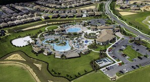 An aerial view of a resort with multiple swimming pools, a parking area, and a road network. - NEAR DISNEY, GOLF, SPA, Game room, Kids room 19015 (Four Corners)