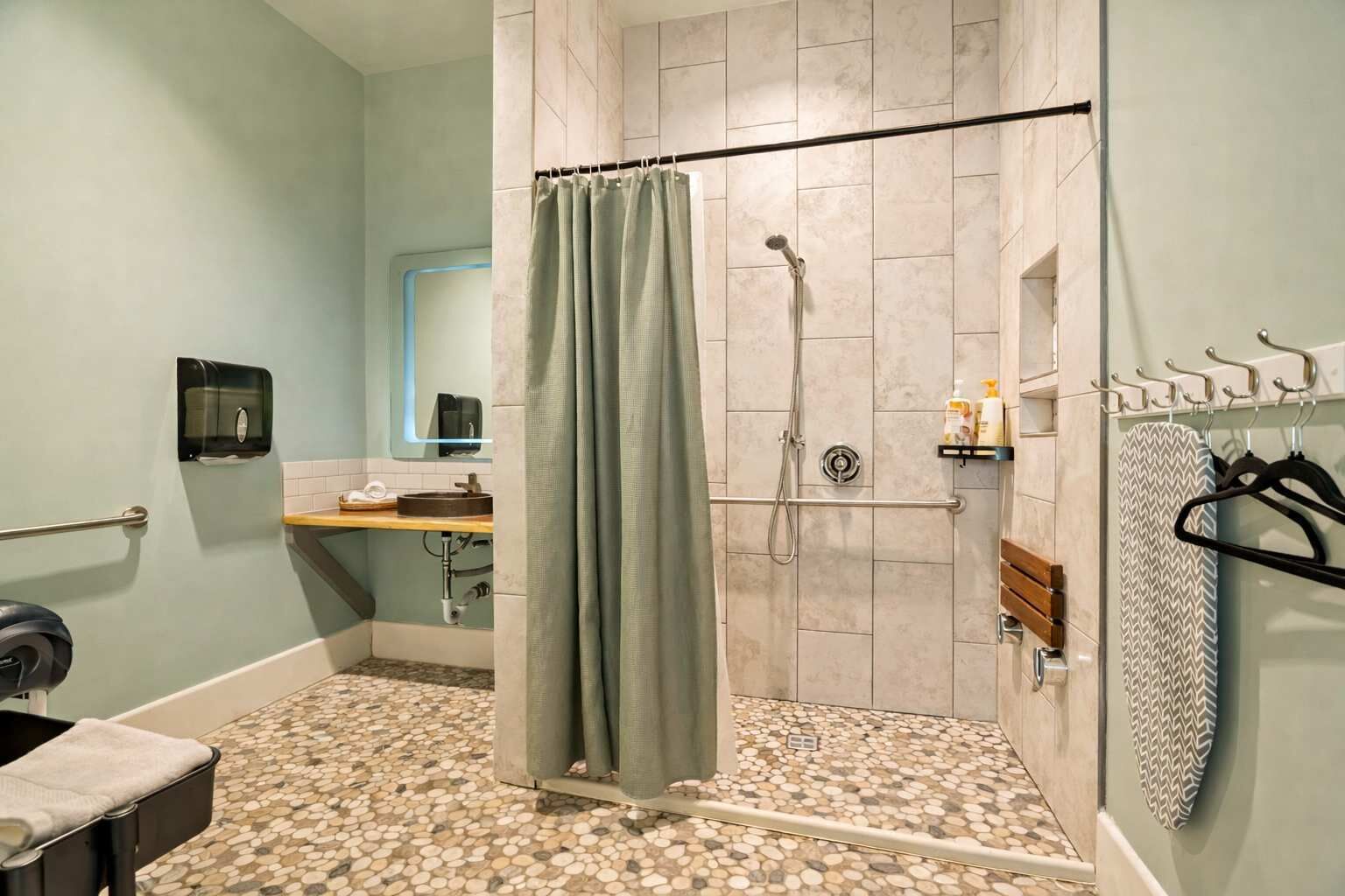Un baño con ducha, inodoro, lavabo, toallero y espejo.
