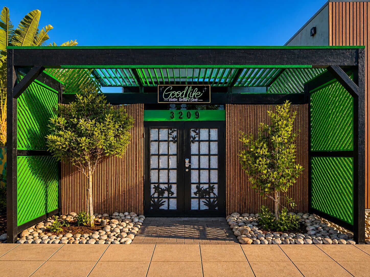 A building with a green and black facade, a sign reading 'Goodlife,' and a number '3209' above the entrance.