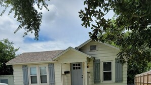 A single-story house with a front porch, a garage, and a well-maintained lawn. - Cozy 3/2 cottage near Memorial Hospital. (Lake Charles)