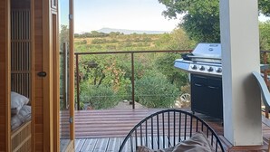 A balcony with a view of a vineyard, a grill, and a bed with pillows. - SERENA 🏡.<br><br>Near the Pont d'Avignon.<br>Palace of the Popes.<br>Pont du Gard, Nîmes (Tavel)