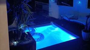 A swimming pool with a blue-lit edge, surrounded by potted plants and a brick wall. - SERENA 🏡.<br><br>Near the Pont d'Avignon.<br>Palace of the Popes.<br>Pont du Gard, Nîmes (Tavel)