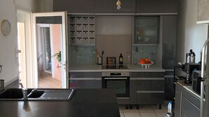 A modern kitchen with a central island, built-in appliances, and a view to the adjacent living area. - SERENA 🏡.<br><br>Near the Pont d'Avignon.<br>Palace of the Popes.<br>Pont du Gard, Nîmes (Tavel)