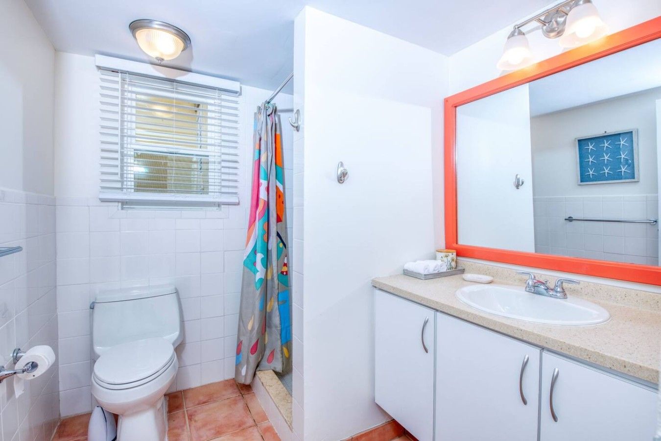 Un baño con inodoro, lavamanos y cortina de ducha.