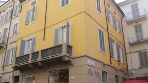 Um edifício amarelo com uma loja no andar térreo e apartamentos nos andares superiores.