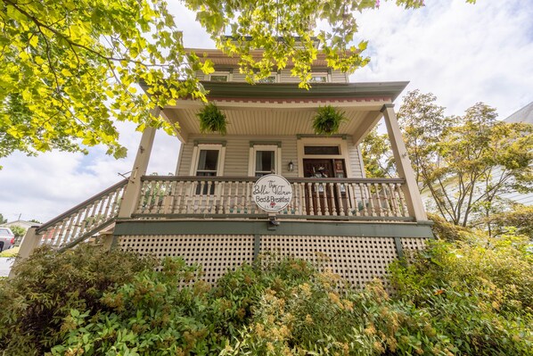 Un edificio de dos pisos con un balcón y un letrero que dice 'Bella Vienna Bed & Breakfast'.