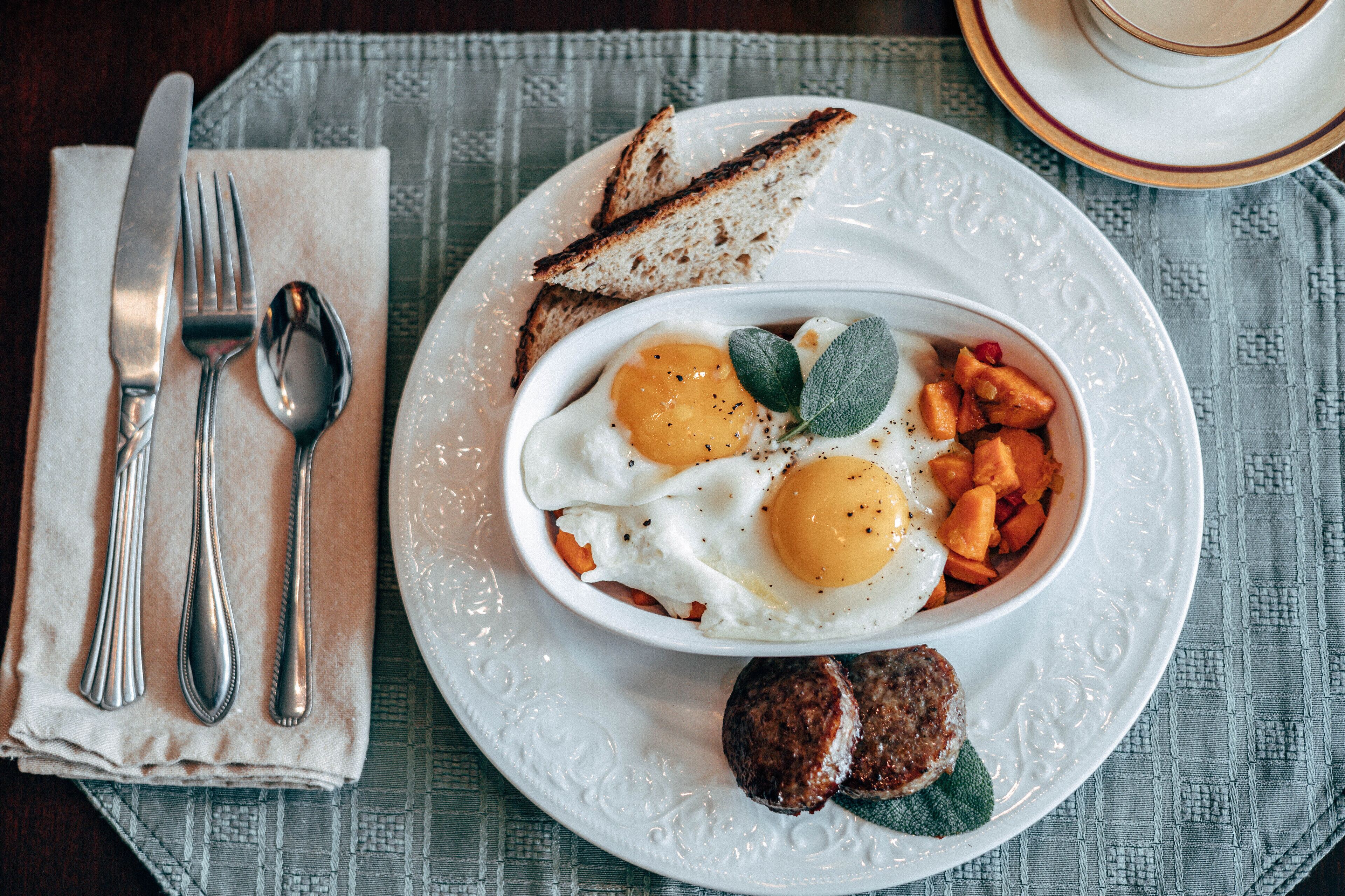 A breakfast plate with eggs, toast, and sausage.