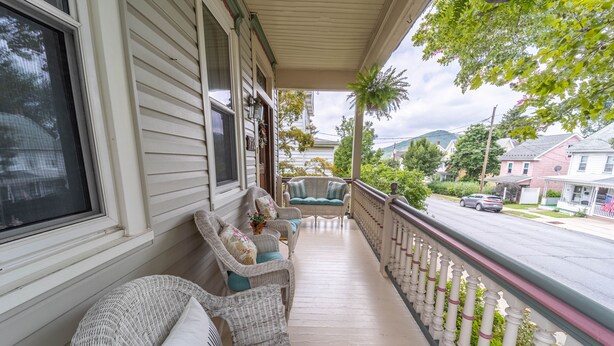 A porch with wicker furniture, a railing, and a view of the street. - The Bella Victoria- Adult Only (Jim Thorpe)