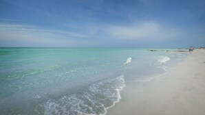 A beach with clear turquoise water and a sandy shore. - Panoramic Gulf Views at Ocean Sands in Madeira Beach~ OS502 (Madeira Beach)