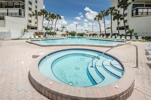 Relax by the resort pool, surrounded by palm trees and lounge chairs.