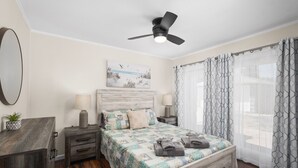 A bedroom with a bed, bedside tables, a ceiling fan, and a window with curtains. - Clean 3B/1Bth EasyA to US99 + CA41 & to Nat'l Parks (Fresno)