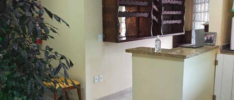 A kitchen with a central island, wooden cabinets, and a potted plant.